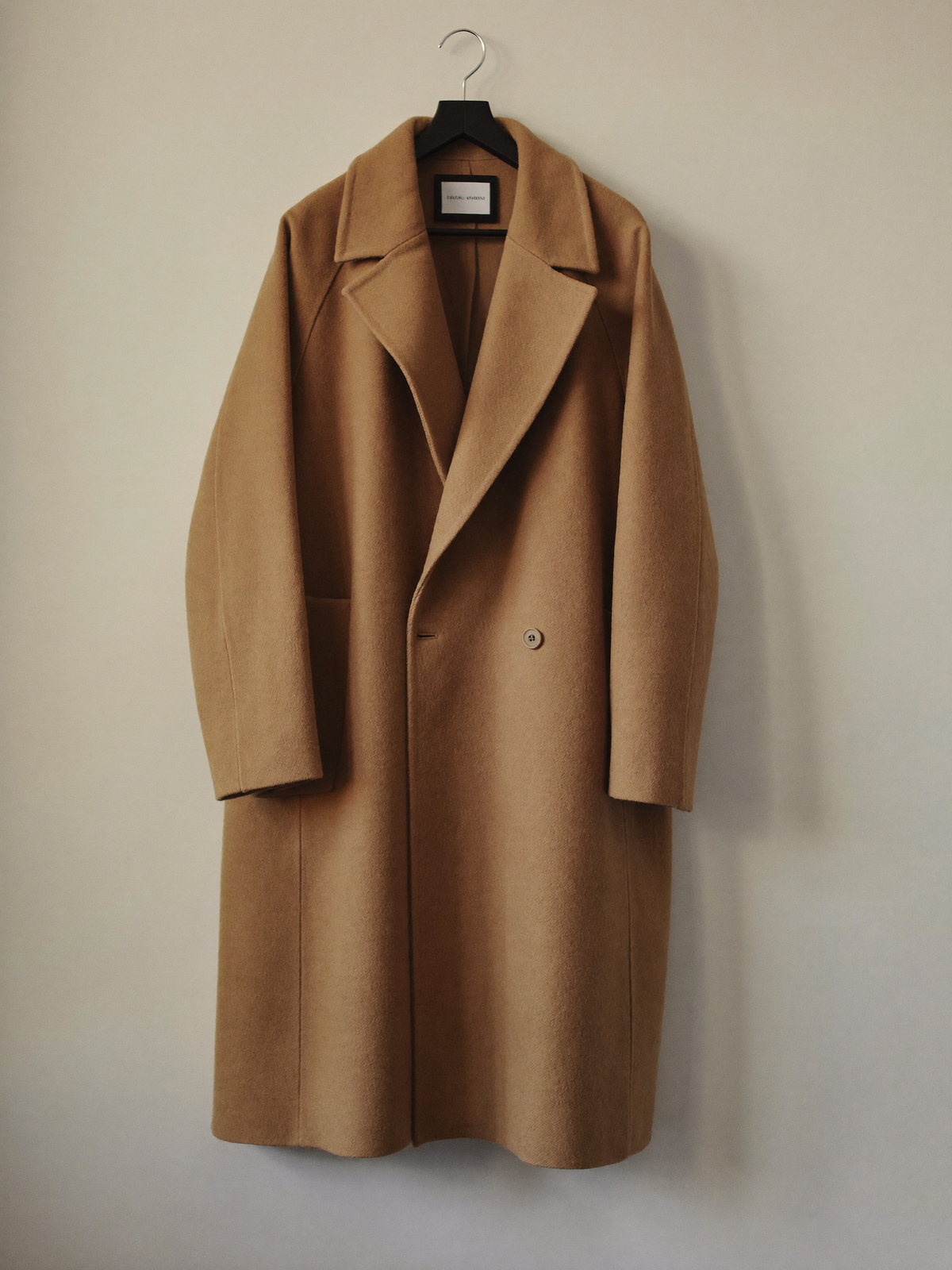 Tailored camel wool coat on a neutral backdrop