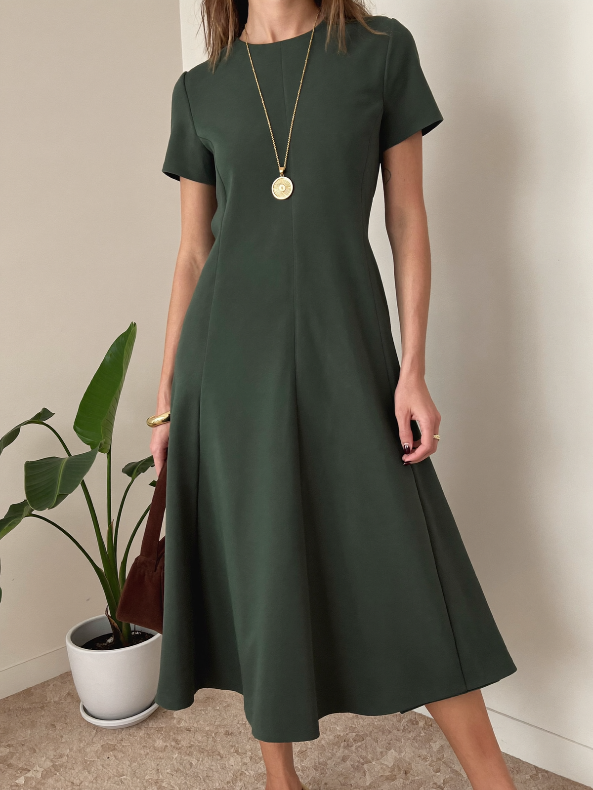 Dark green satin midi dress with gold jewelry
